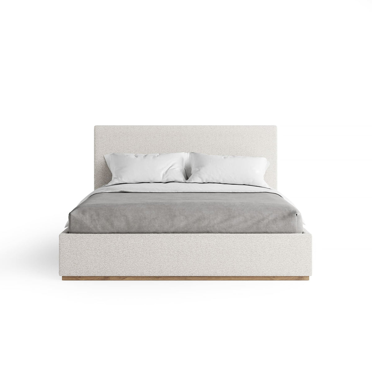 Bed with white bedding and headboard on a white background