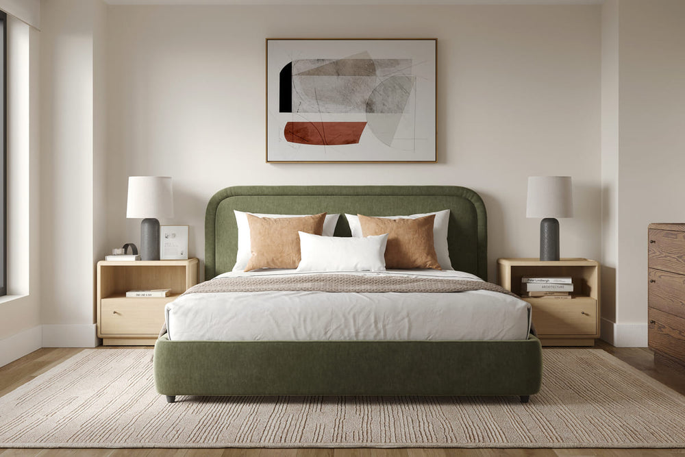 Green bed in a bedroom with abstract art on the wall