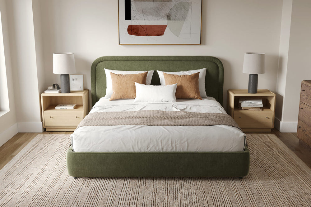 Bedroom with a green upholstered bed, wooden nightstands, and a lamp.