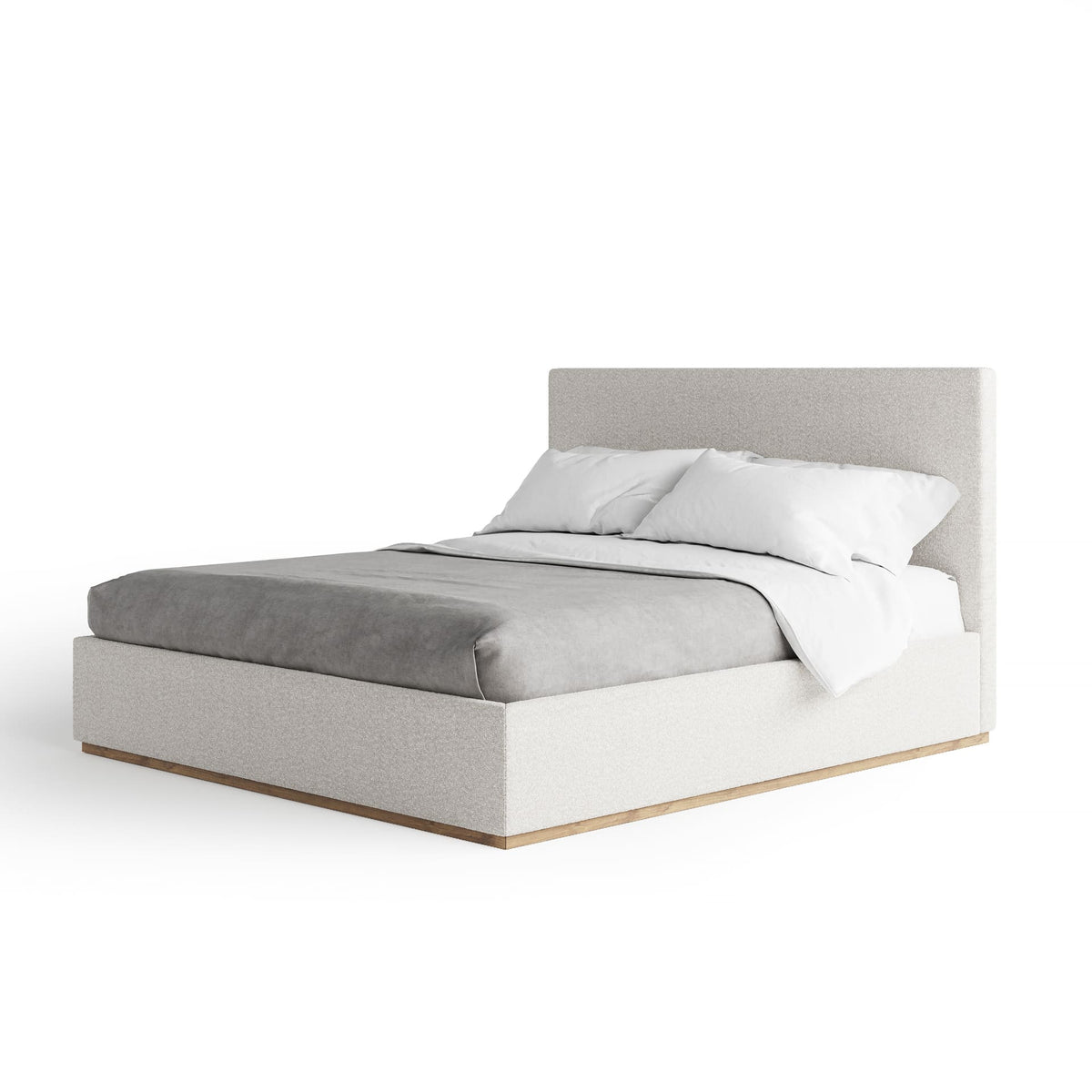 Bed with gray bedding and white pillows on a white background