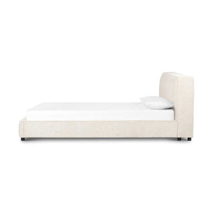 Beige upholstered bed with white mattress and pillow on a white background