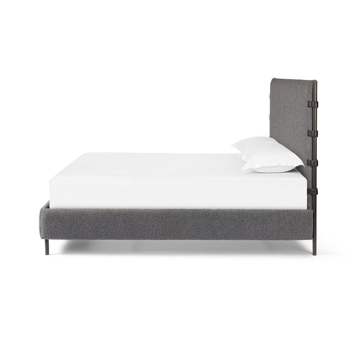 Gray upholstered bed with white mattress and pillow on a white background