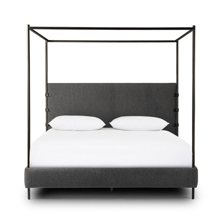 Four-poster bed with black metal frame and gray upholstered headboard on a white background
