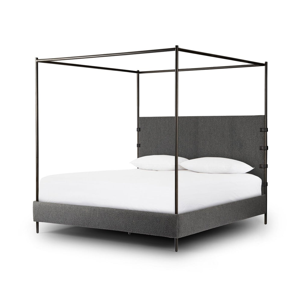 Canopy bed with gray upholstered headboard and white bedding on a white background