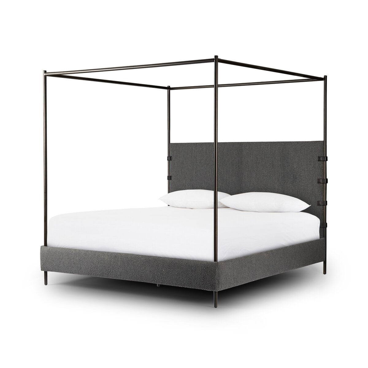 Canopy bed with gray upholstered headboard and white bedding on a white background