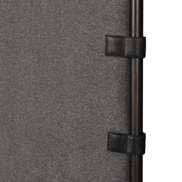 Close-up of a textured gray surface with black straps and buckles.