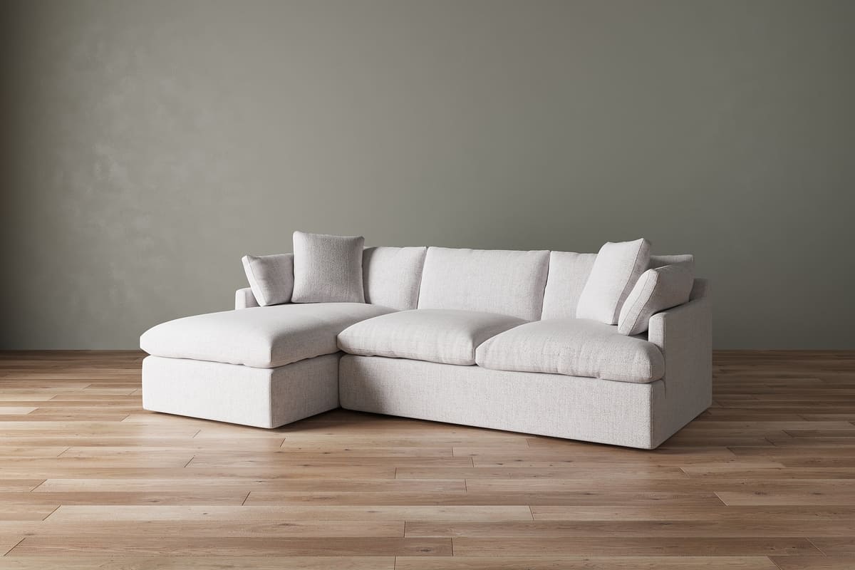 White sectional sofa against a gray wall on a wooden floor