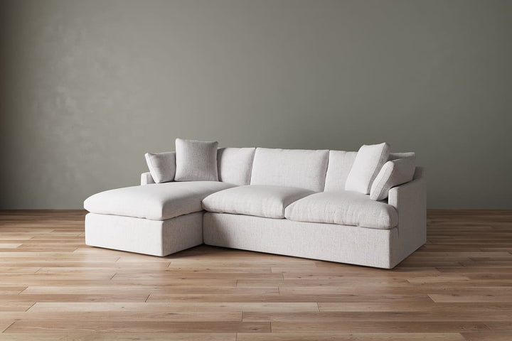 White sectional sofa against a gray wall on a wooden floor