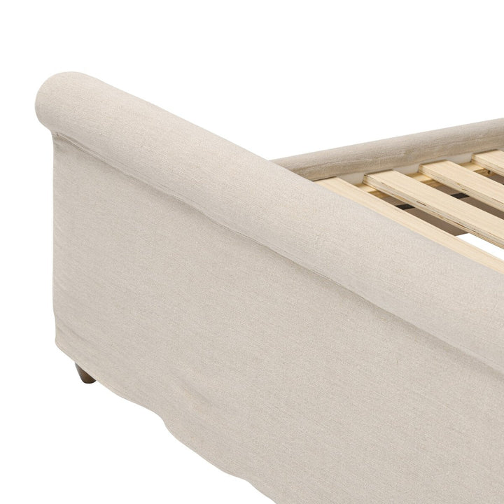Beige upholstered bed frame with wooden slats on a white background