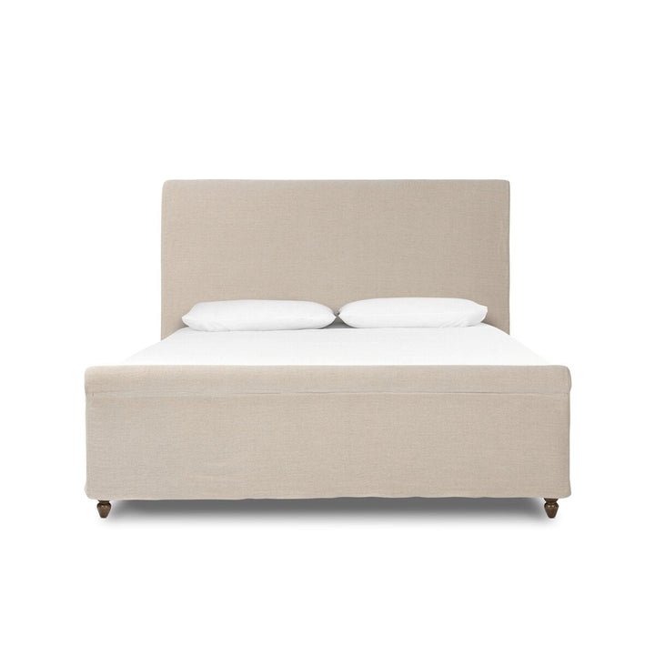 Beige upholstered bed with white bedding on a white background