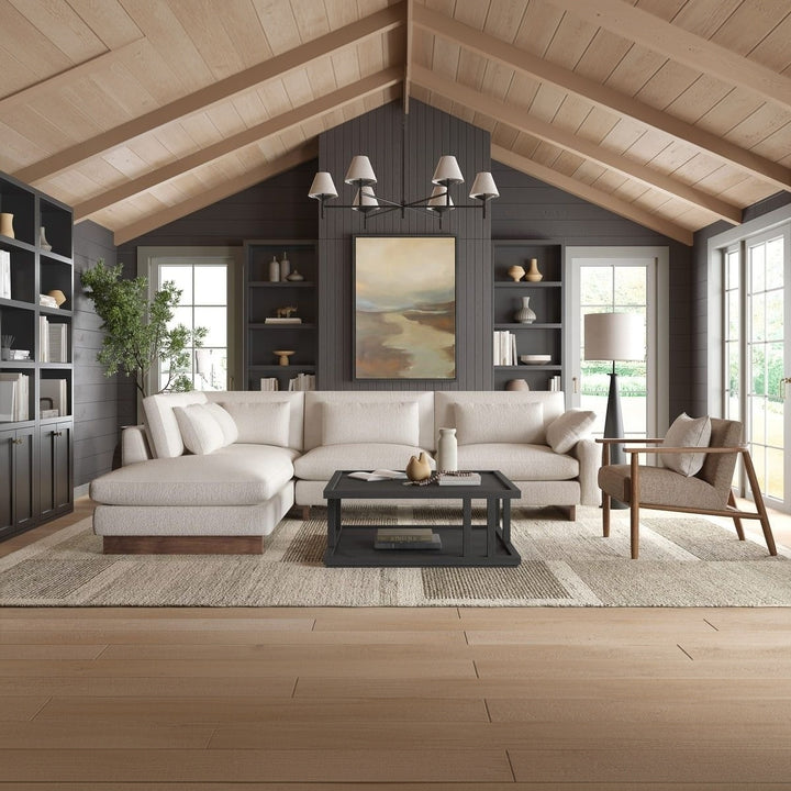 Modern living room with a sectional sofa, coffee table, and bookshelves.