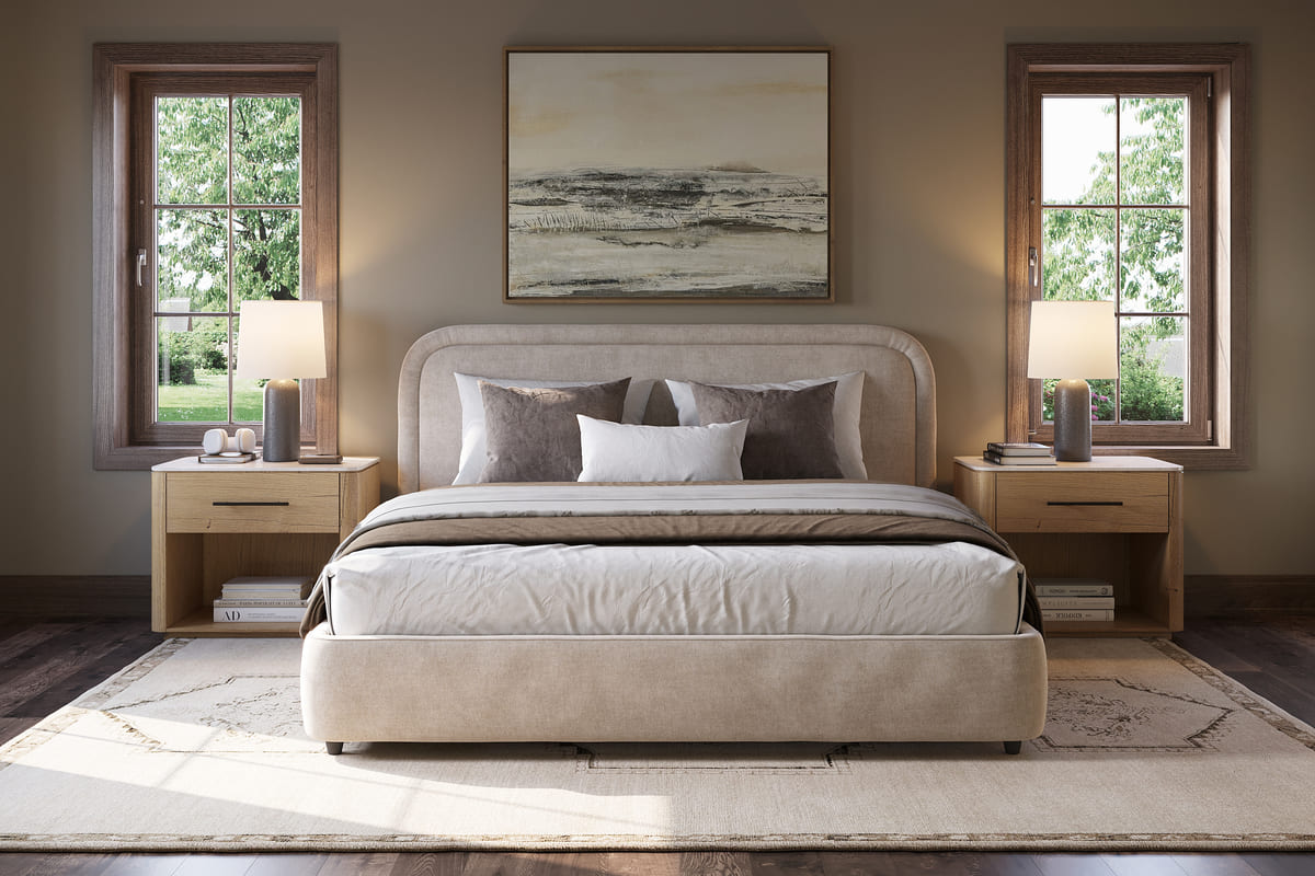 Neatly made bed with beige bedding in a bedroom setting with two windows and a painting.