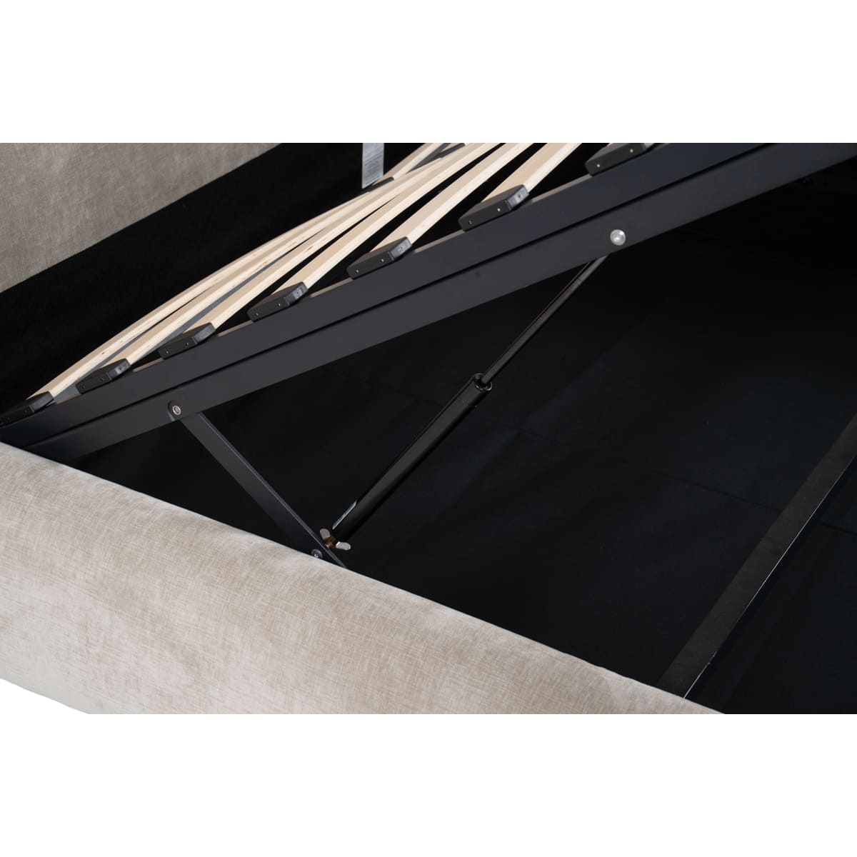 Close-up of a black metal bed frame with wooden slats underneath.