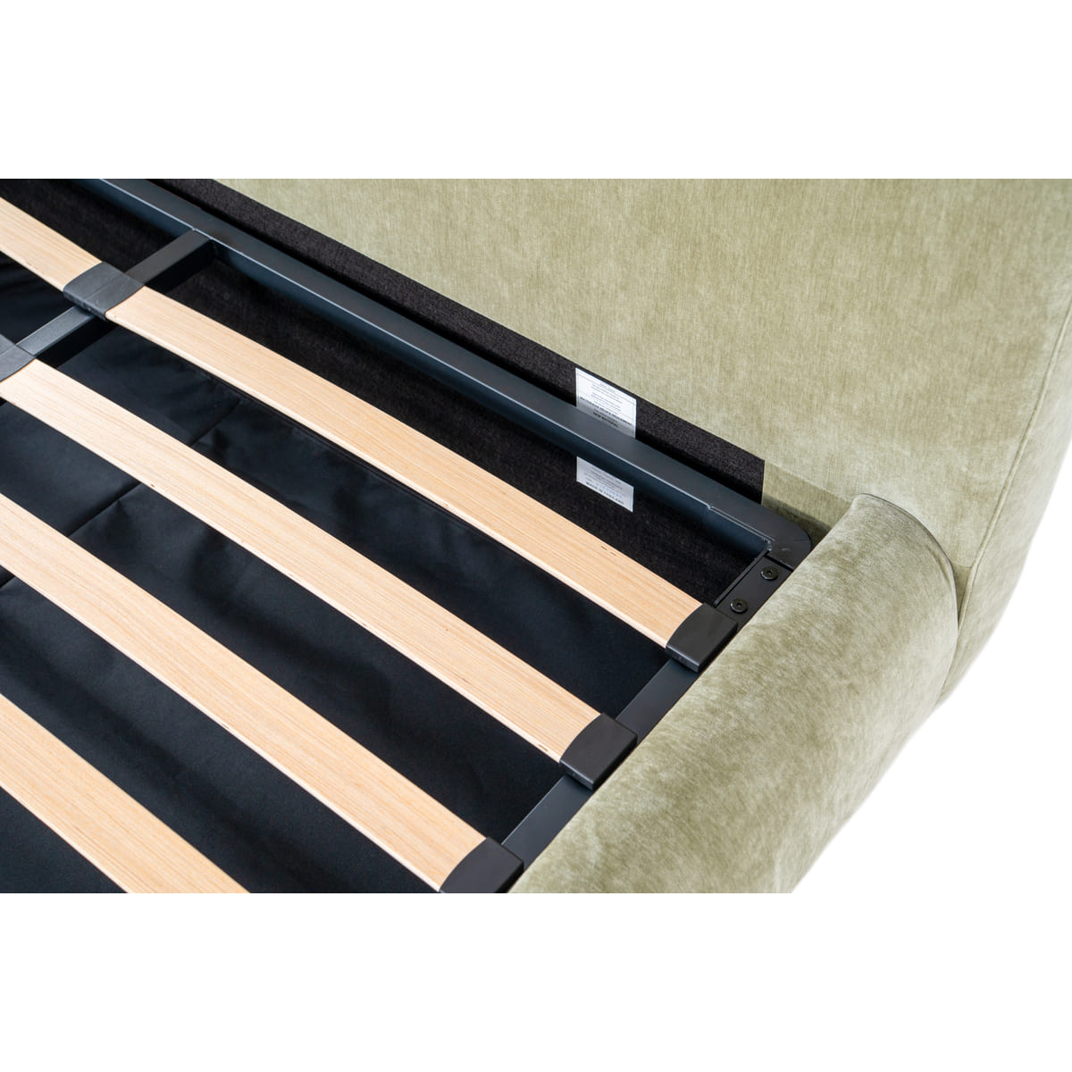 Close-up of a bed frame with wooden slats and beige upholstered headboard.