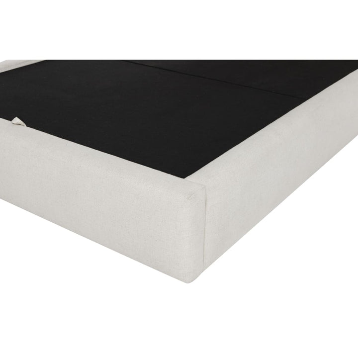 Corner of a bed with black mattress and white box spring on a white background