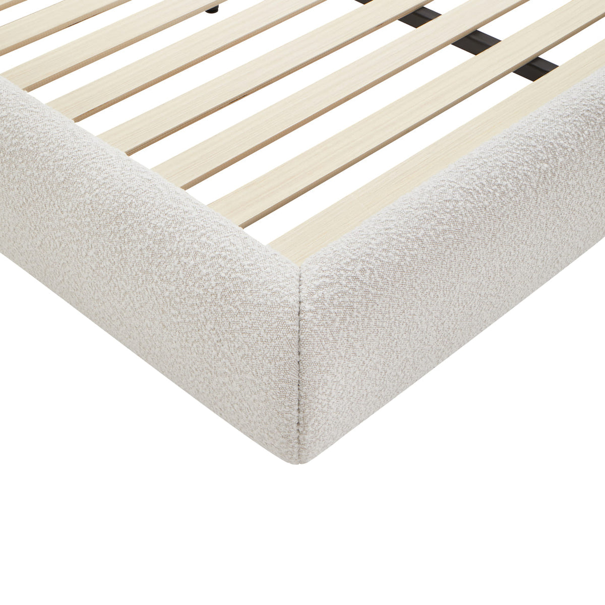 Corner of a bed with wooden slats and white mattress
