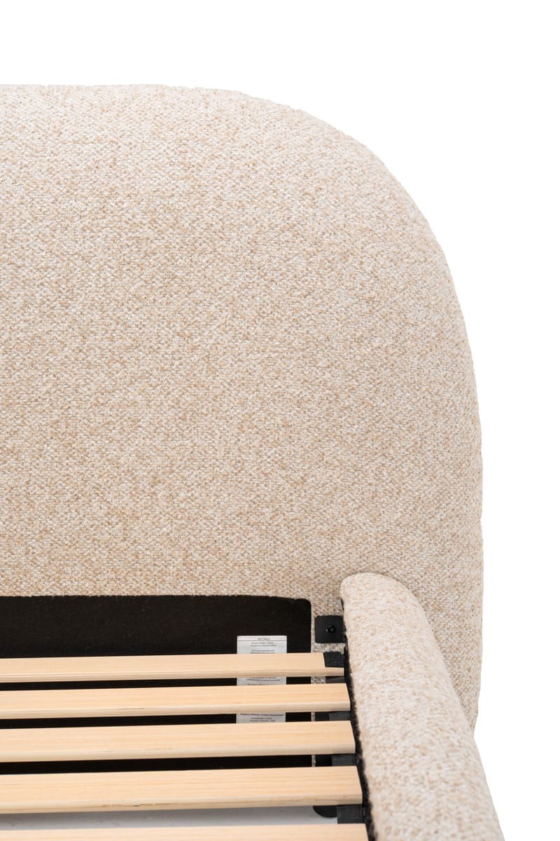 Close-up of a beige upholstered chair with wooden slats on a white background