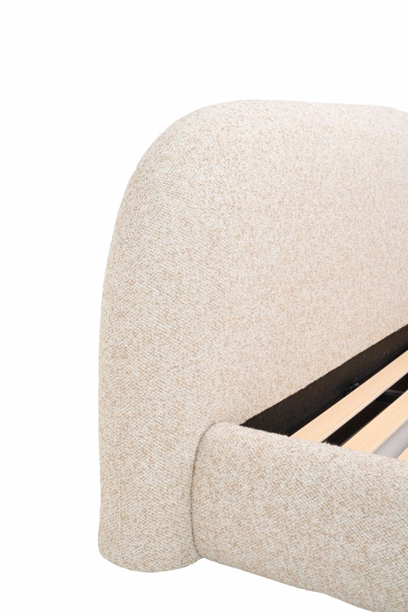 Close-up of a textured beige upholstered headboard on a white background