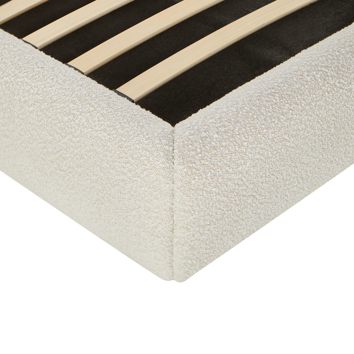 Corner of a bed with wooden slats and beige fabric base on a white background