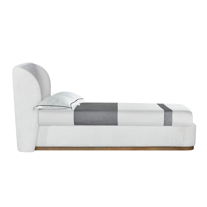 Modern white bed with gray striped blanket on a white background