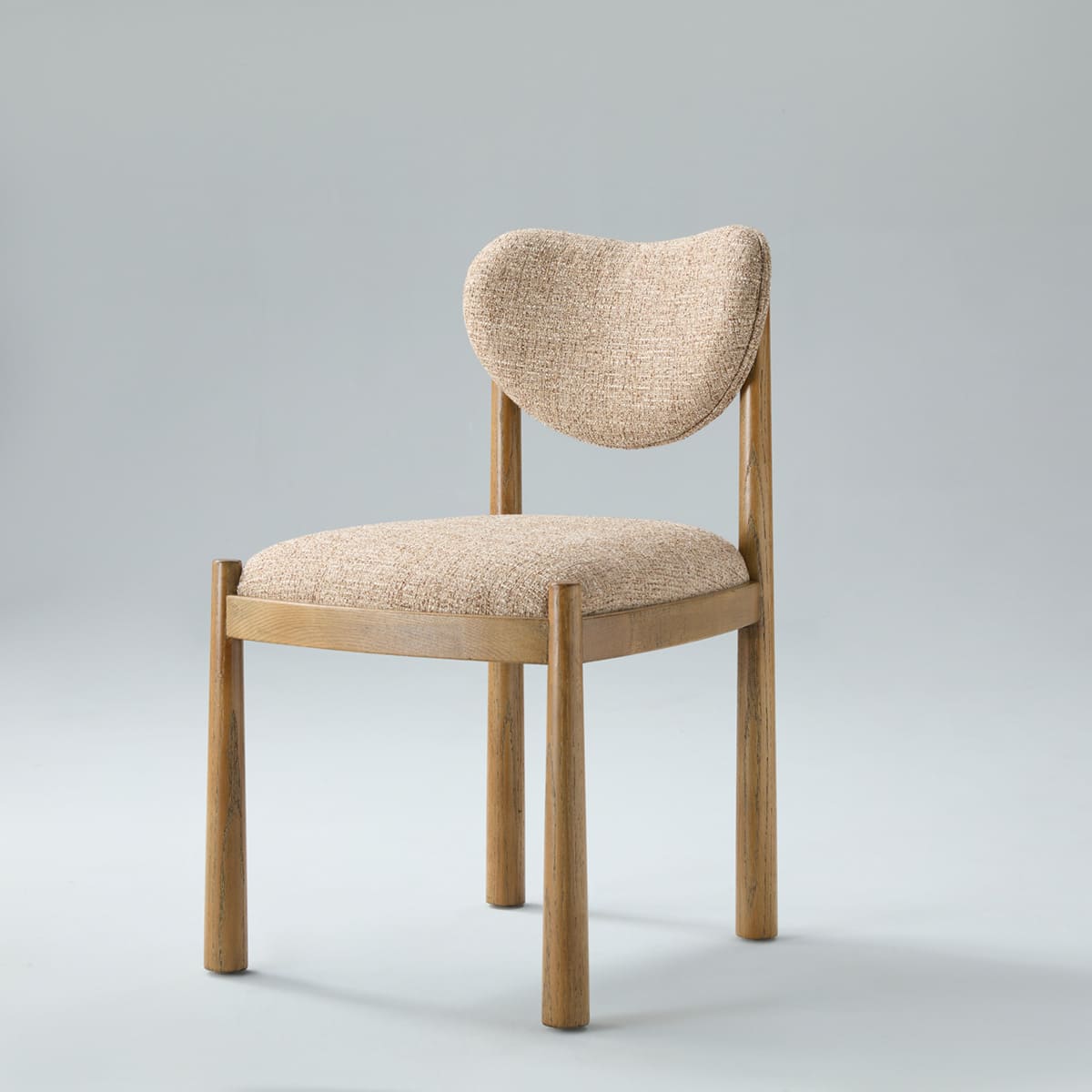 Vela Upholstered Dining Chair with solid light oak frame, cylindrical legs, and warm beige textured upholstery featuring a kidney-arched floating backrest